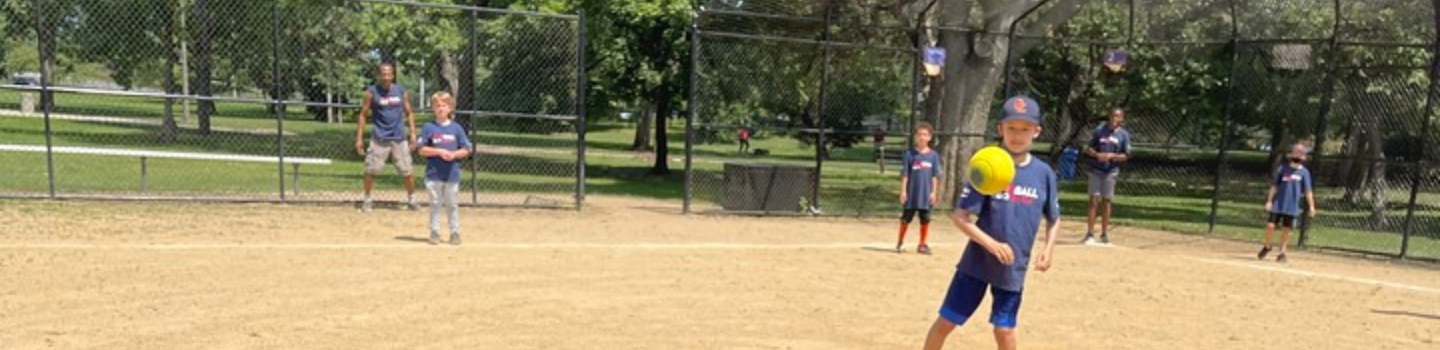 Child playing kickball on a baseball field.